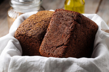 Side view on two loafs of rye bread in a basket with napkin