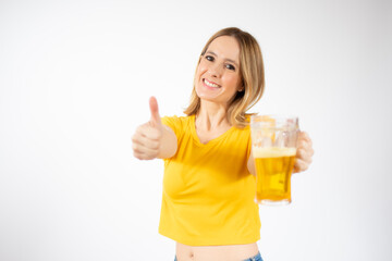 Cheerful young woman holding a beer mug full of beer and smiling over white background
