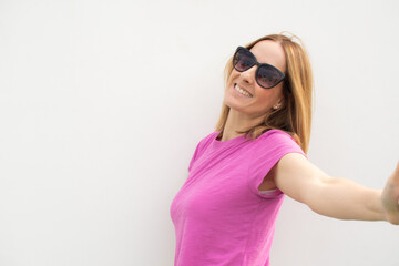 Young smiling woman wearing sunglasses standing outdoors