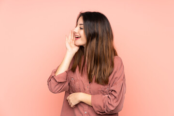 Young caucasian woman isolated on pink background shouting with mouth wide open to the lateral