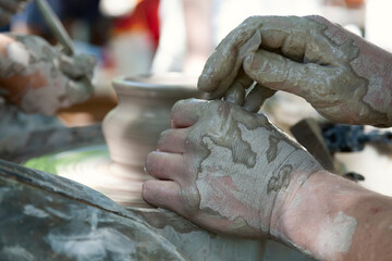 Potter shaping a ceramic pot on a pottery wheel