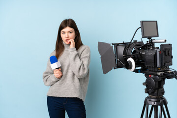 Young reporter woman holding a microphone and reporting news nervous and scared