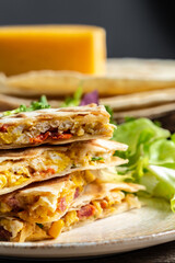 Traditional Mexican tortillas with quesadilla with scramble eggs, vegetables, ham and cheese. Mexican cuisine, Mexico and Latin America traditional restaurant menu dish
