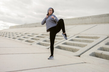 Sporty woman fighter stands in a fighting stance outdoors