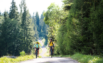 Family with small children cycling outdoors in summer nature.