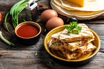 Quesadilla with scramble eggs, vegetables, ham and cheese. Mexican food cuisine traditional dish. Mexican tortilla quesadilla