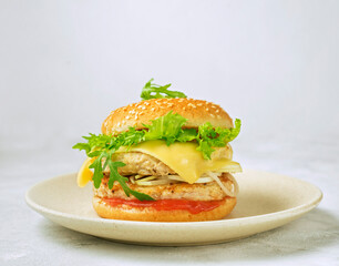 hamburger with cheese and herbs on a white plate, Cheeseburger on a light plate