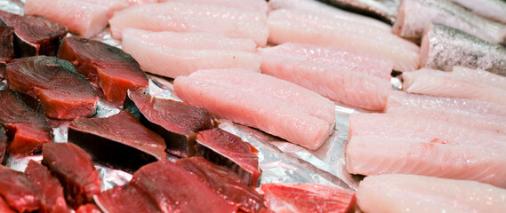 Fish market with fresh tuna steak and many other white fish meat.