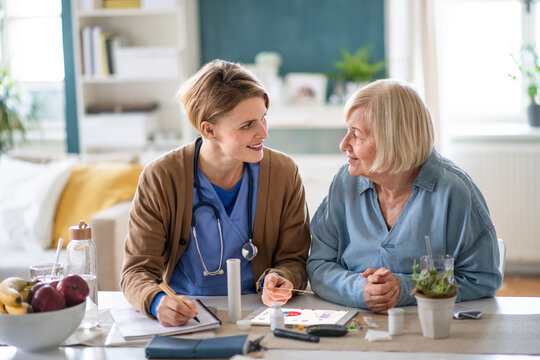 Caregiver or healthcare worker with senior woman patient, explaining how to use litmus paper.