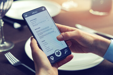 person choosing food for dinner from mobile phone app menu at restaurant