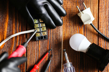 a man fixing an electric lamp, dielectric gloves, a screwdriver. Wire connector, top view, wood...