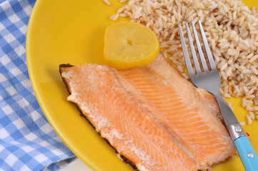 Filet de truite avec du riz et une rondelle de citron dans une assiette en gros plan