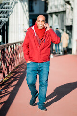 black man in the city of Lyon, France. On the street using his smart phone