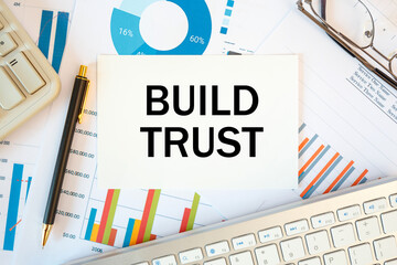 BUILD TRUST is written in a document on the office desk, diagram and keyboard