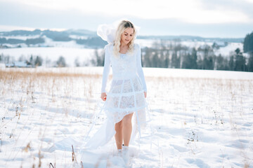 Frau in weißem Schneekleid Haute Couture Hochzeitskleid Designerkleid weiß Winterlandschaft Schnee kalt Freude lacht