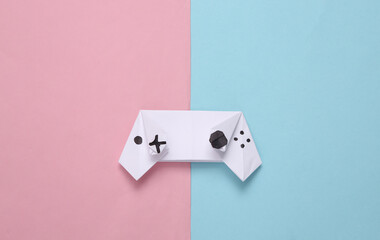 Origami gamepad on blue pink pastel background