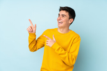 Teenager caucasian handsome man isolated on purple background pointing with the index finger a great idea