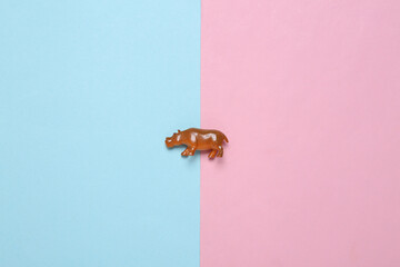 Hippo figurine on a blue-pink pastel background. Top view