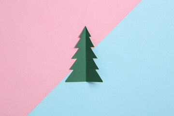 Paper cut christmas tree on blue pink pastel background