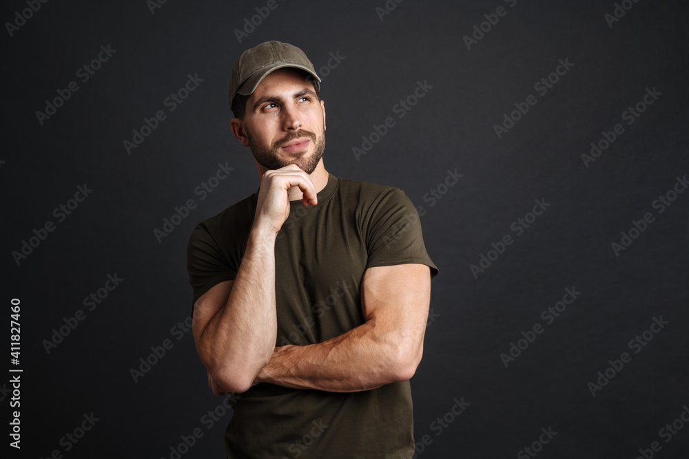 Wall mural Focused masculine military man posing and looking aside