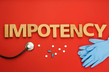 Flat lay composition with word IMPOTENCY on red background