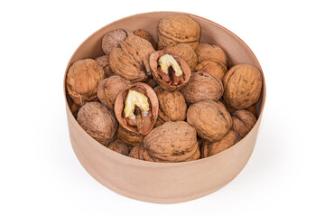 Dried walnuts in shells in a wooden round box