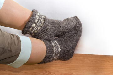 Thick wool socks on women legs against the wooden floor © An-T