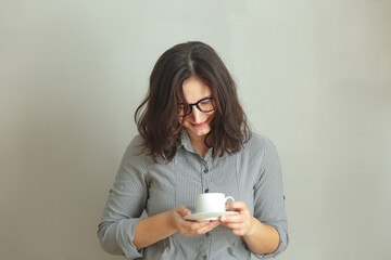 Smiling brunette business Woman or student Holding Coffee Cup Against gray Background isolated