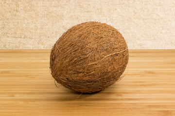 Whole coconut fruit on a bamboo wooden surface