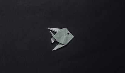 Origami fish on black background