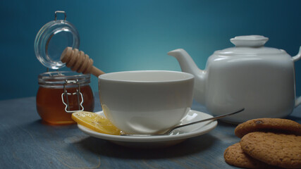 Tea pot, tea cup, honey and cookies