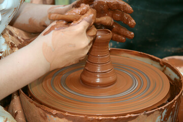 Potter shaping a ceramic pot on a pottery wheel