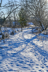 trail with footprints in snow near stone wall