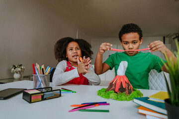 Children making DIY volcano model from kids play clay