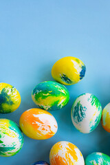 Top view of multicolored Easter eggs on a blue background. Happy Easter card. Dyed Easter eggs. Copy space for your text. Flat lay style. Top view. 
