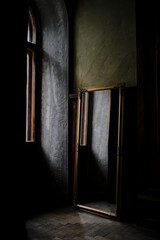 Antique mirror, stands by the window in a vintage room, beautiful apartment