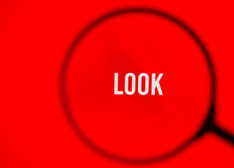 Word look on red screen through magnifying glass.