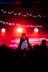 Fototapeta na wymiar Person close up of recording video with smartphone during a concert.