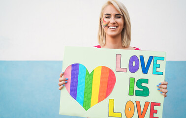 Gay woman holding love is love banner at lgbt pride parade - Focus on face