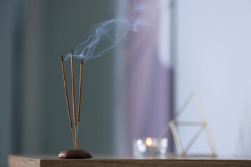 Incense sticks smoldering on table indoors, space for text