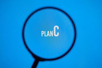 Text plan C on blue screen through magnifying glass. Strategy