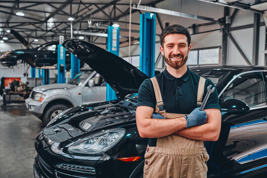 Close up view of a smiling mechanic inside his auto repair shop.