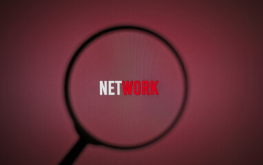 Word network on burgundy screen through magnifying glass.