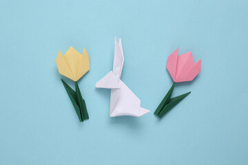 Origami easter bunny with tulips on blue background. Spring background