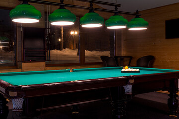 Sports game of billiards on a green cloth. Multi-colored billiard balls with numbers on a pool table