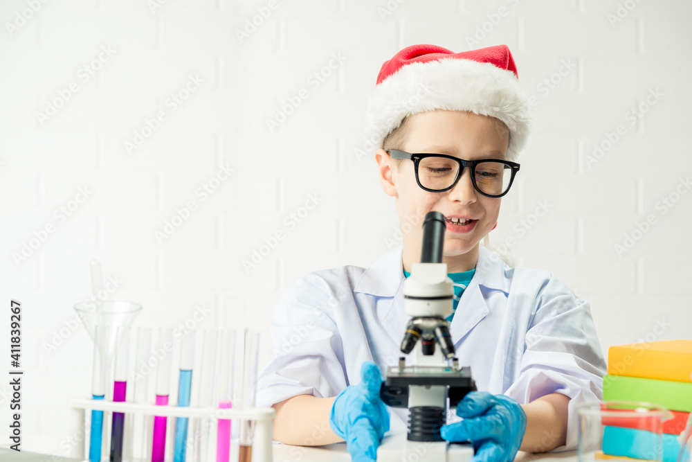 Wall mural student learning chemistry. positive joyful smart boy testing and using a microscope in science clas