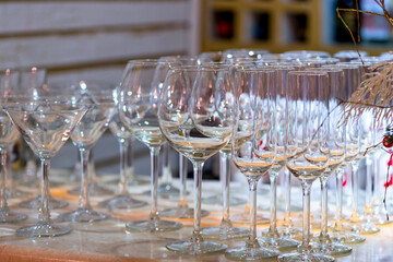 set of empty glass goblets for champagne, wine, water stand in row on table