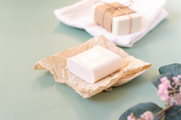 Flower, craft paper, cotton fabric, soap, over green background. Zero waste, natural organic bathroom tools. Plastic free life. Ecological skin care, body treatment concept