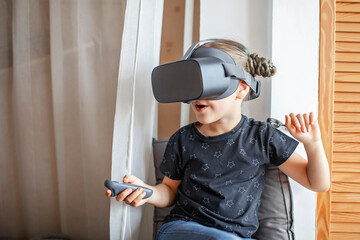 Cute girl wearing virtual reality googles at home, remote education experiment, future today, new...