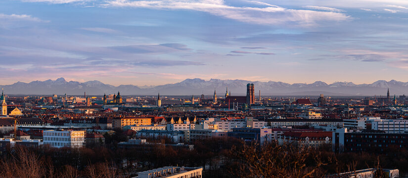 M&uuml;nchen w&auml;rend Sonnenuntergang bei F&ouml;n mit sch&ouml;nen Wolken und Stadtblick